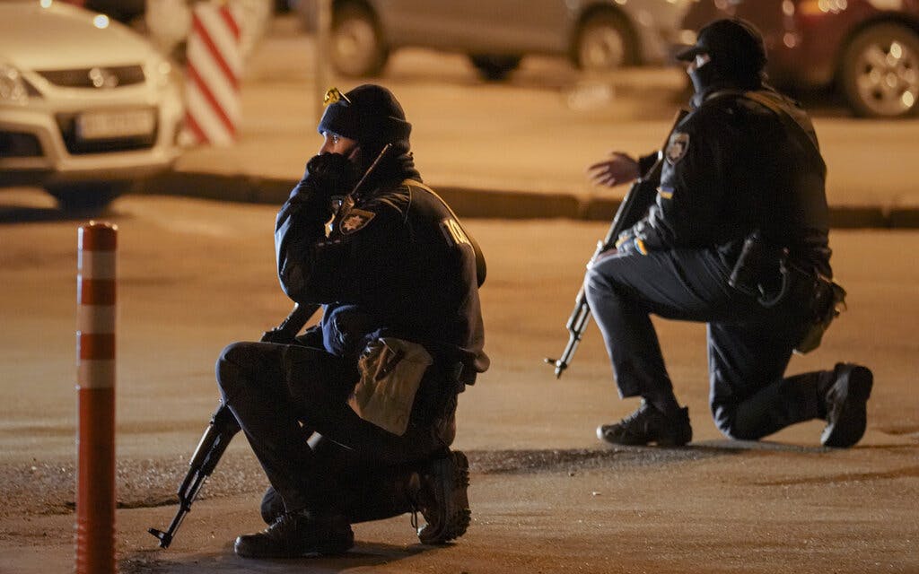 Ukrainian police kneel during an airstrike alarm  at Kiev February 28, 2022. AP/Vadim Ghirda