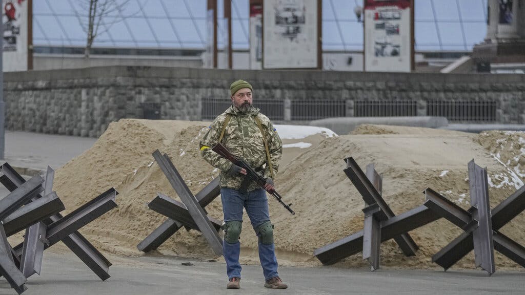 An armed man stands near a barricade at Maidan Square in Kiev. AP Photo/Vadim Ghirda