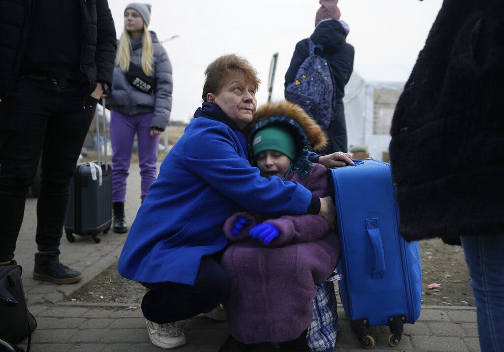 A woman holds a small girl at a border crossing, at Medyka, Poland, March 3, 2022. AP Photo/Markus Schreiber