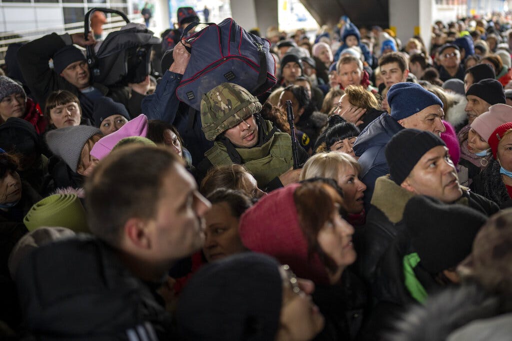 A Ukrainian soldier is among the crowd as people push to enter a train to Lviv at the Kyiv station March 4. 2022. AP/Emilio Morenatti
