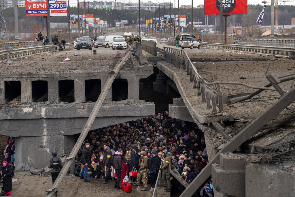 Ukrainians crowd under a destroyed bridge as they try to flee Kiev March 5, 2022. AP/Emilio Morenatti