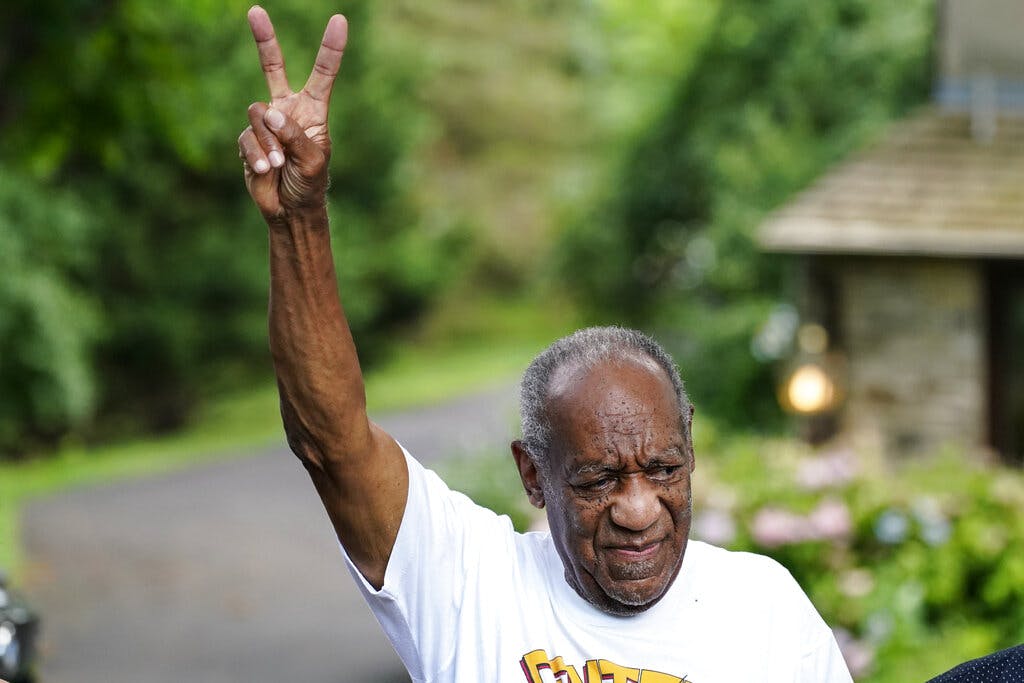Bill Cosby gesturing outside his home after being released from prison in June, 2021. AP Photo/Matt Rourke, File
