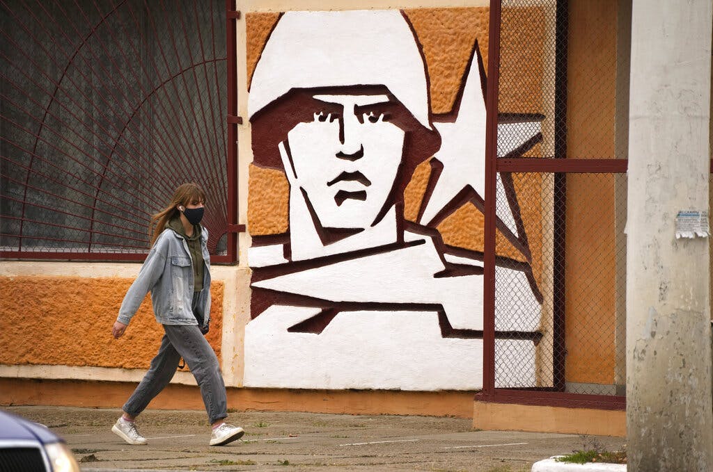A woman walks past the Operational Group of Russian Forces headquarters at Transnistria in Moldova. AP Photo/Dmitri Lovetsky, File