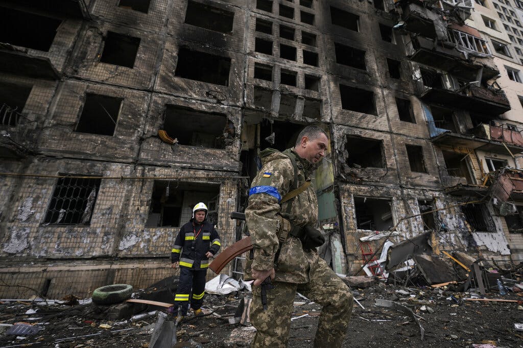 Ukrainian soldiers and firefighters search around a destroyed building after a bombing attack in Kiev March 14, 2022. AP/Vadim Ghirda