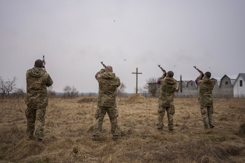 Ukrainian military servicemen fire salutes to fallen comrades during a funeral at Starychi, western Ukraine, March 16, 2022. AP/Bernat Armangue