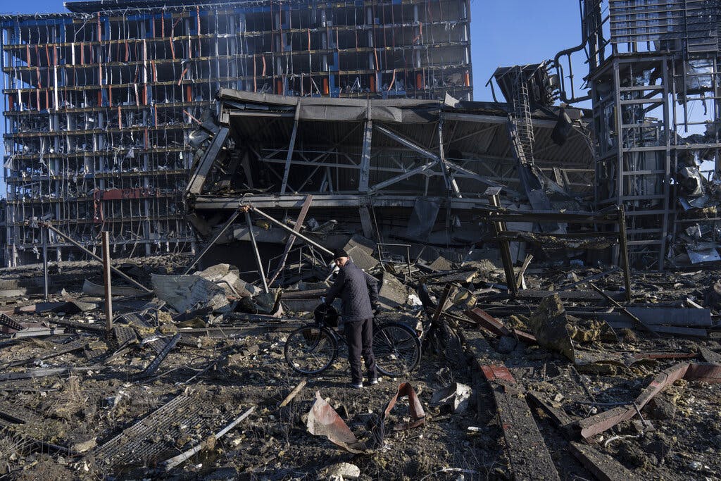 A man stands with his bicycle amid the destruction caused by shelling of a Kiev shopping center March 21, 2022. AP/Rodrigo Abd