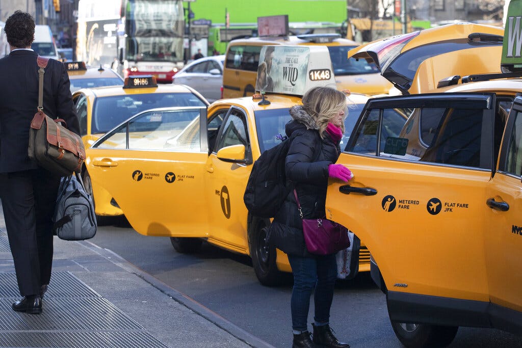 A passenger gets into a taxi at New York City. AP Photo/Mark Lennihan, file