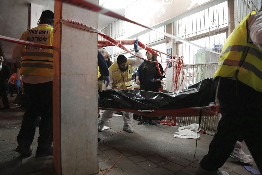 A body is removed from the site where a gunman opened fire in Bnei Brak, Israel, March 29, 2022. AP/Oded Balilty