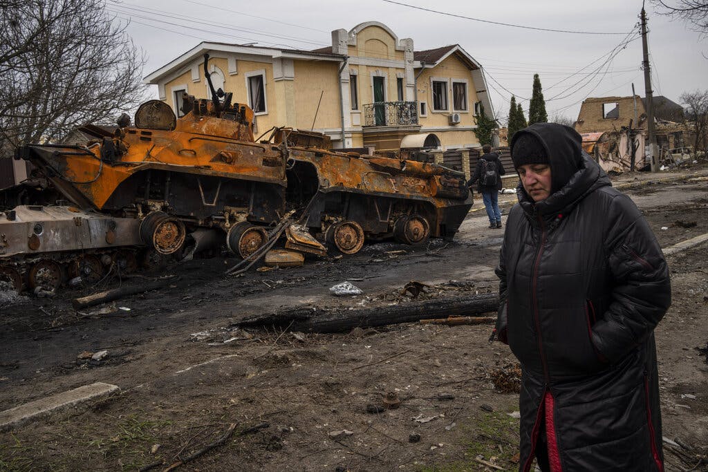 A woman walks next to a destroyed Russian military vehicle at Bucha, outside Kiev, Ukraine, on Tuesday. AP Photo/Rodrigo Abd