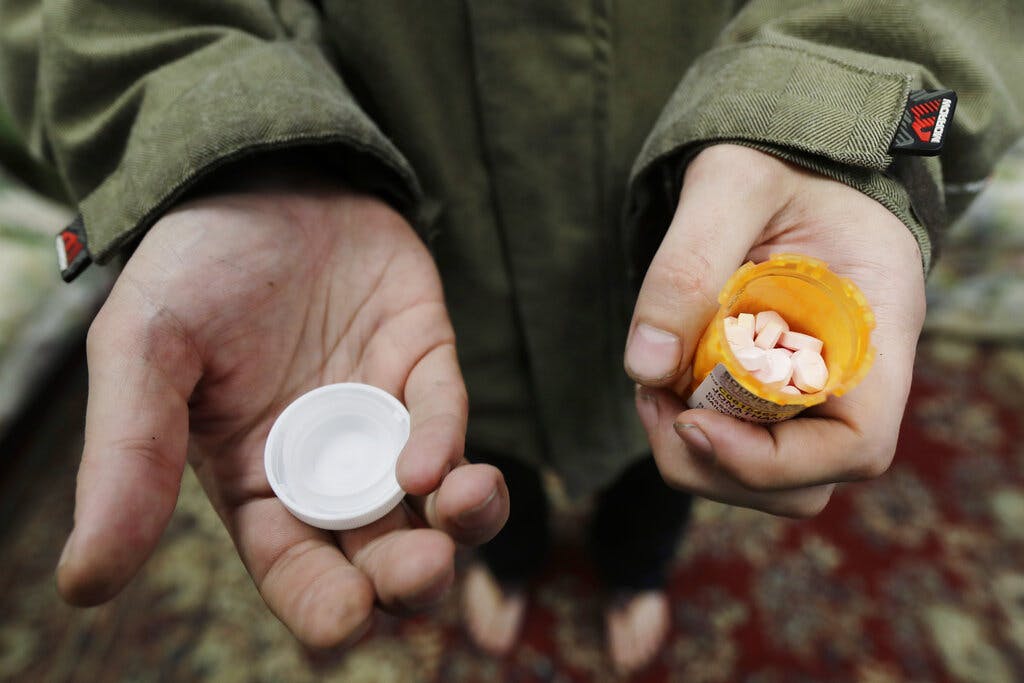 A patient holding a bottle of buprenorphine, a medicine to prevent withdrawal sickness in people trying to stop using opiates. AP Photo/Ted S. Warren, file