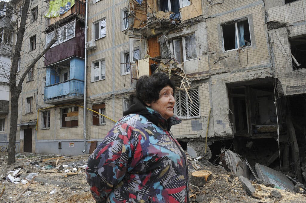 A Kharkiv, Ukraine, woman walks past an apartment building damaged by shelling on Sunday. AP Photo/Andrew Marienko