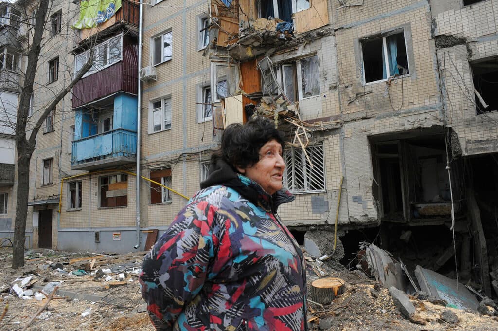 A Kharkiv, Ukraine, woman walks past an apartment building damaged by shelling on Sunday. AP Photo/Andrew Marienko