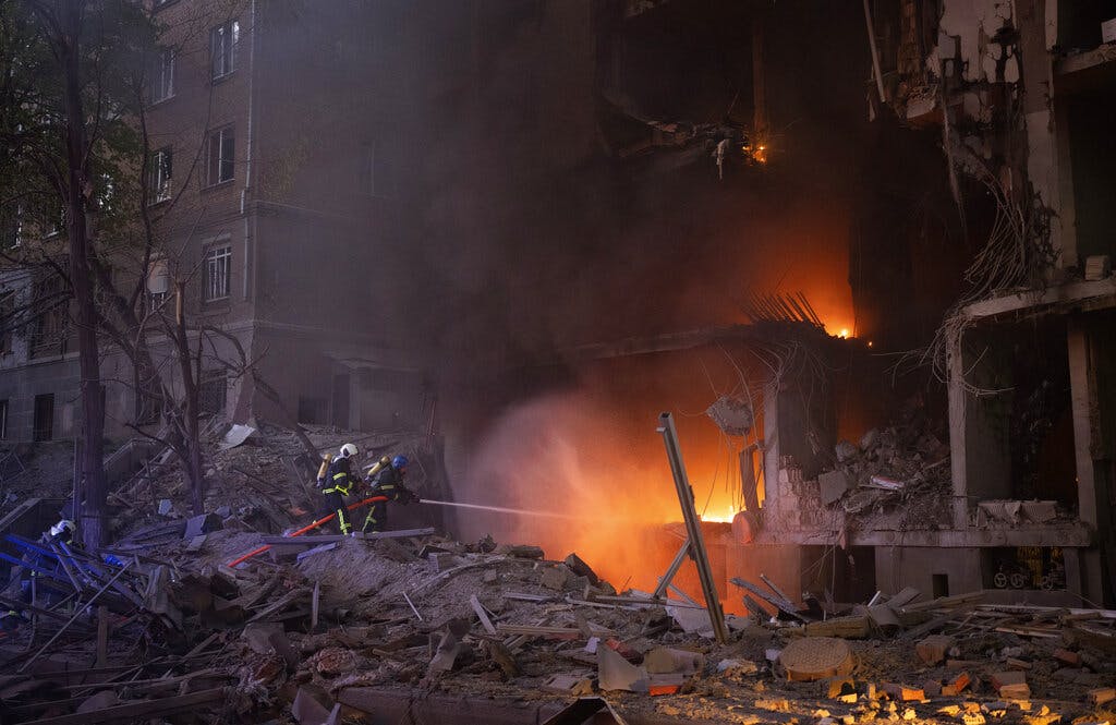 Firefighters try to put out a fire following an explosion at Kyiv, Ukraine on Thursday, April 28, 2022. AP Photo/Emilio Morenatti