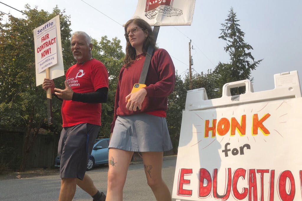 Members of the Seattle Education Association picket outside a school district building at Seattle.