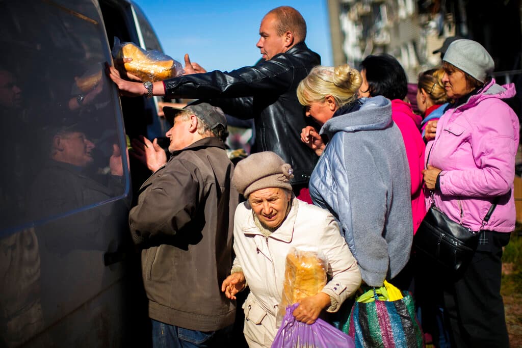AP/Francisco Seco Residents of Izium, Ukraine, receive food and everyday necessities from volunteers October 12, 2022. Izium has had no gas, electricity, or running water supply since the beginning of September.
