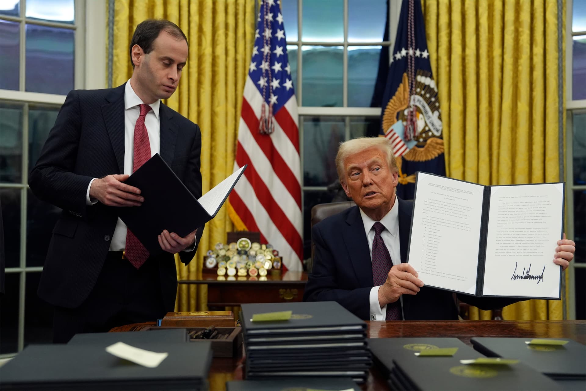 AP/Evan Vucci President Trump holds up an executive order commuting sentences for people convicted of January 6 offenses on January 20, 2025.