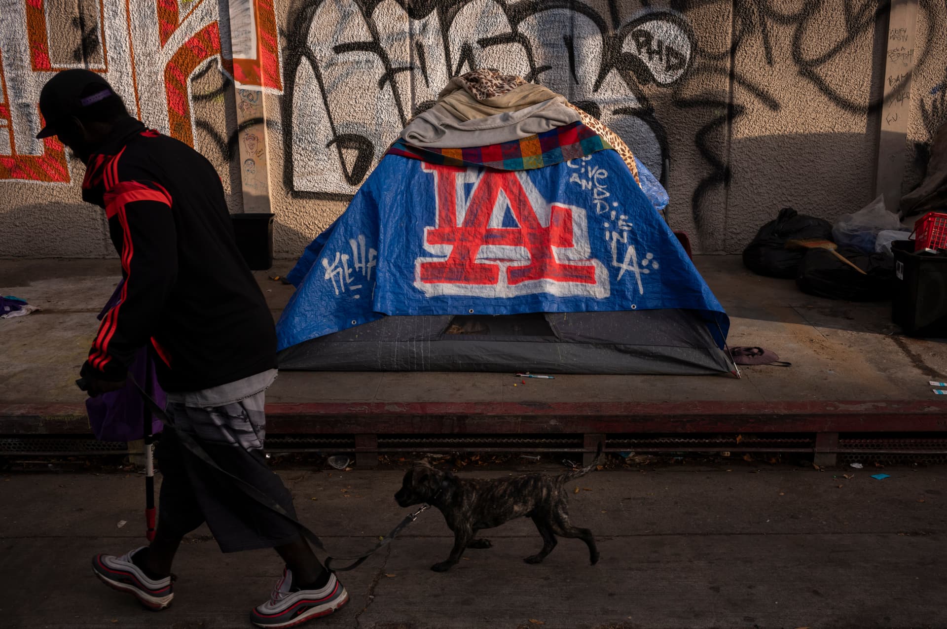AP Photo/Jae C. Hong FILE - A man walks past a homeless encampment at downtown Los Angeles, Oct. 25, 2023.