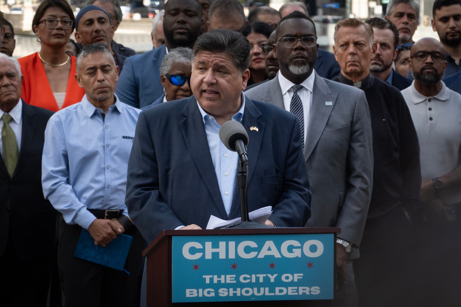 Scott Olson/Getty Images Flanked by Mayor Brandon Johnson, Governor JB Pritzker speaks at a news conference on August 25, 2025, at Chicago.