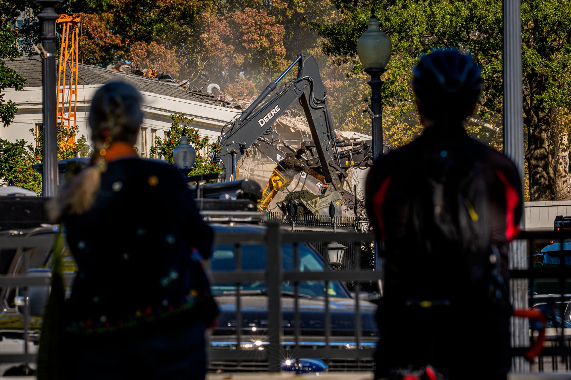 Andrew Harnik/Getty Images Pedestrians watch the facade of the East Wing of the White House being demolished Tuesday.