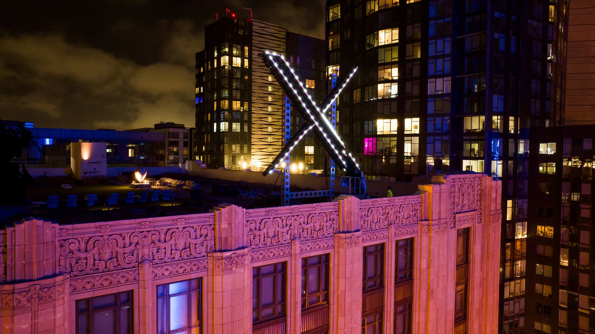 AP/Noah Berger Workers install lighting on an 'X' sign atop the company headquarters in downtown San Francisco.