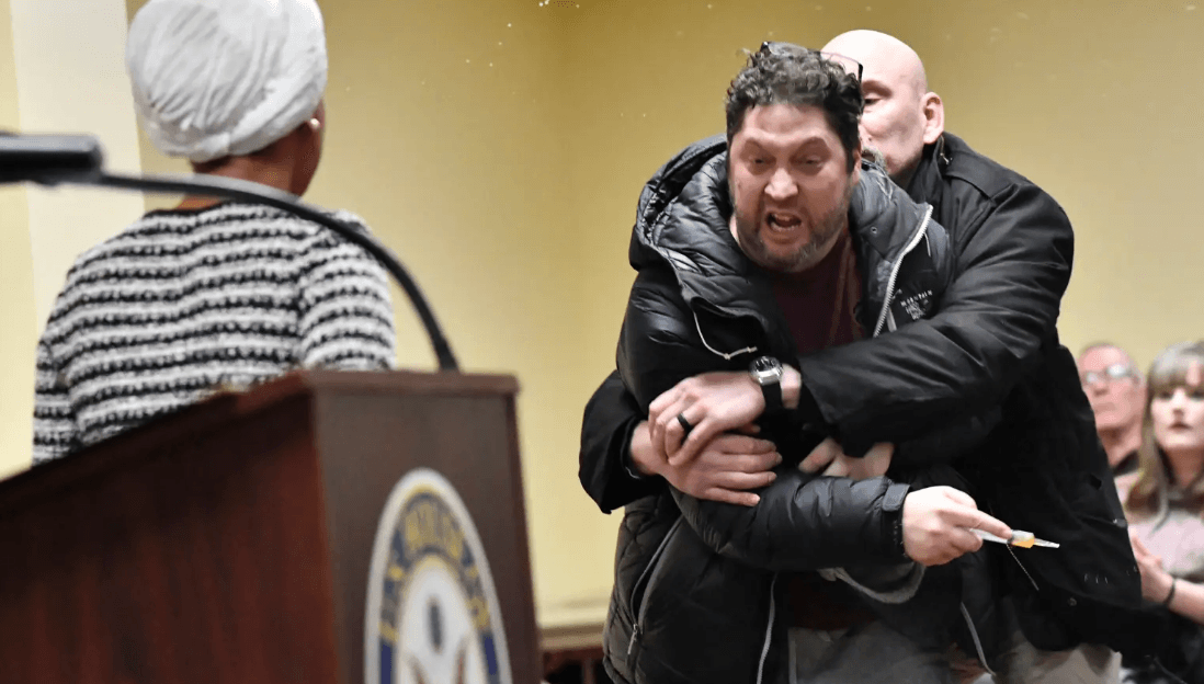 Via X Congresswoman Ilhan Omar on Tuesday night was assaulted by a man at a town hall after he rushed at the podium from which she was speaking and sprayed her with an unknown substance.