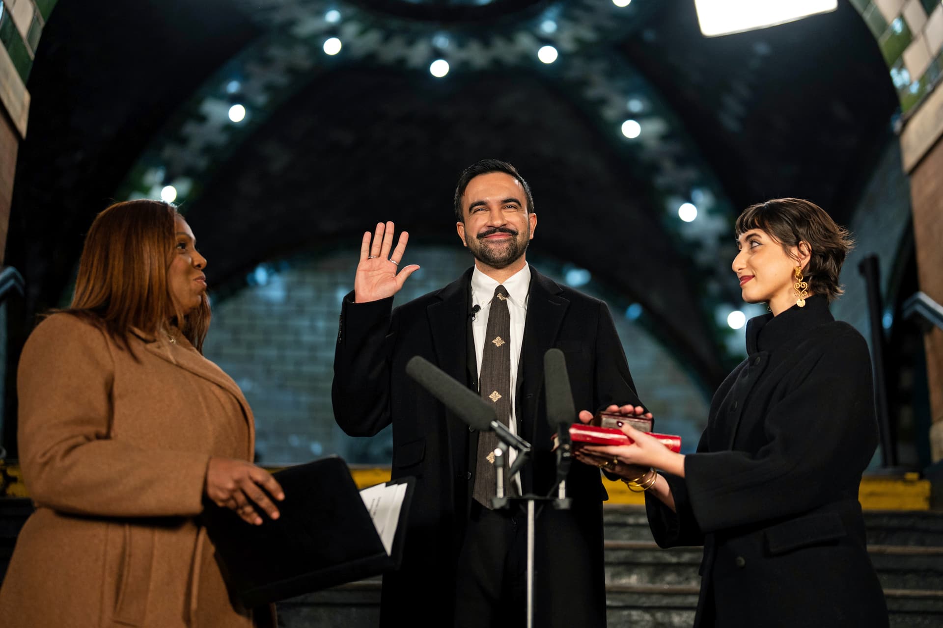 Amir Hamja, pool/Getty Images Mayor Zohran Mamdani is sworn in by Attorney General Letitia James, left, alongside his wife Rama Duwaji, right, at the former City Hall subway station on January 1, 2026.