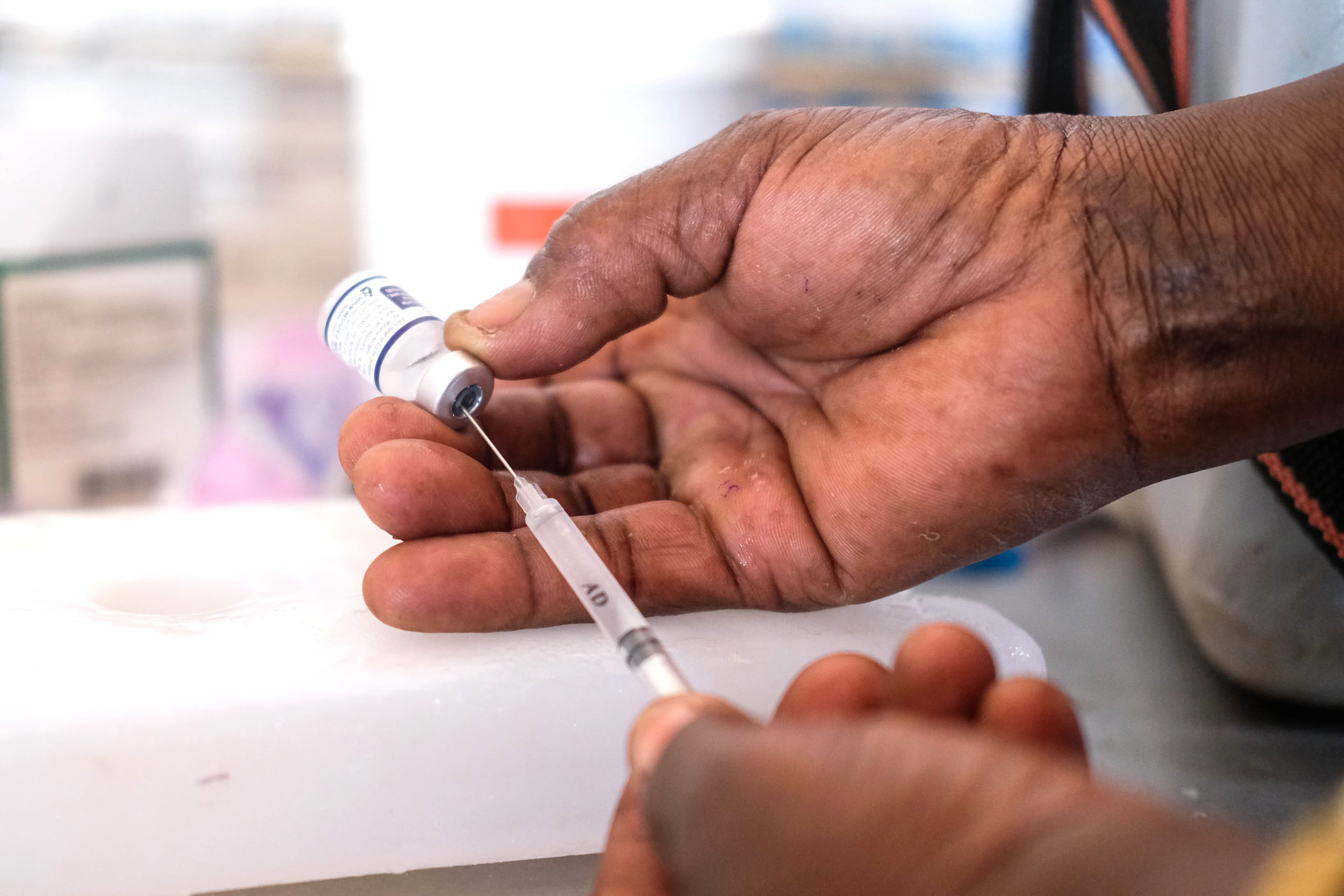 A nurse prepares a vaccine at a hospital in Africa. A nurse prepares a vaccine at a hospital in Africa.