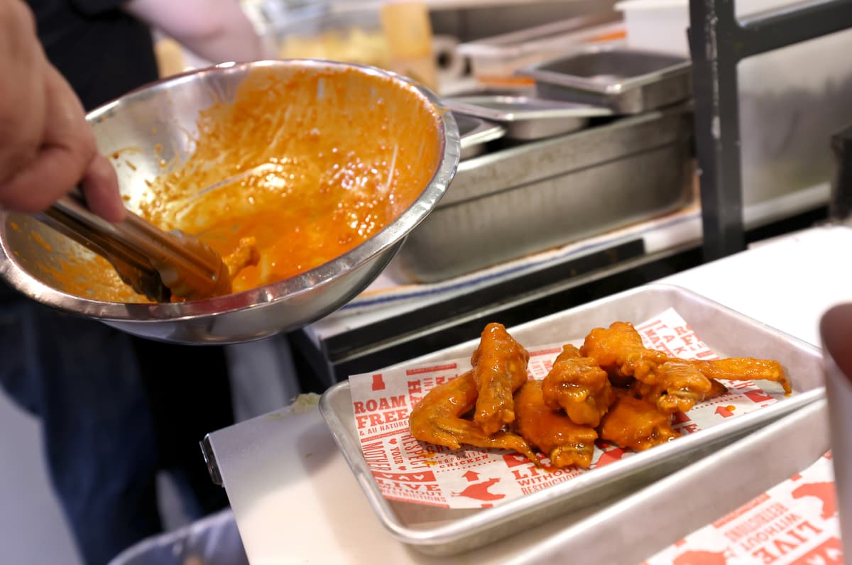 Justin Sullivan/Getty Images A cook prepares Buffalo chicken wings.