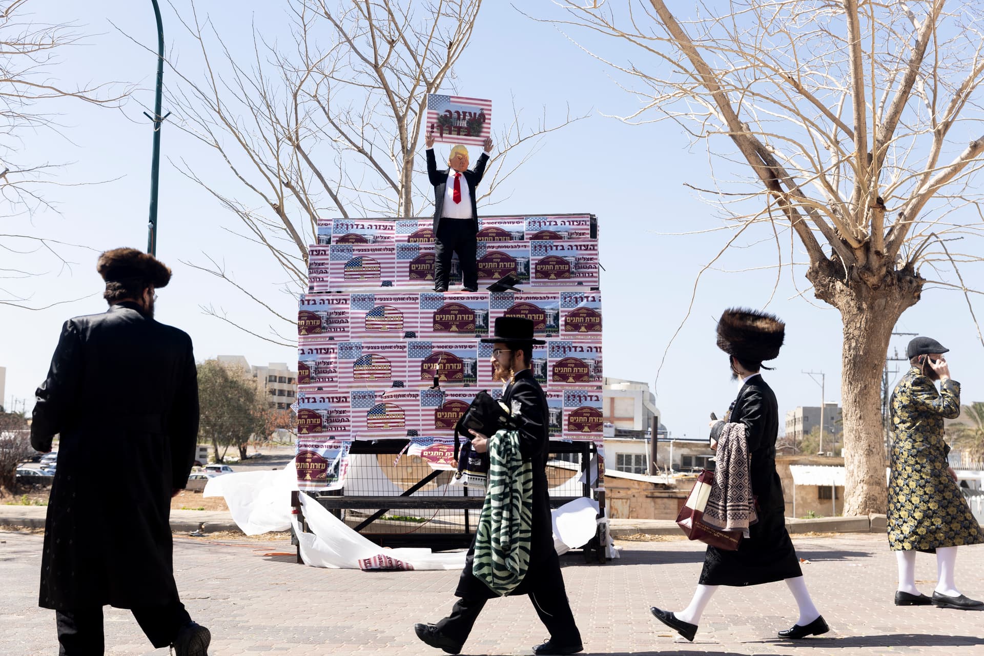 Amir Levy/Getty Images Ultra Orthodox Jewish men walk by an effigy of President Trump holding a sign saying 'Health is on the way' during the Jewish holiday of Purim amid the war with Iran on March 3, 2026 in Netanya, Israel.