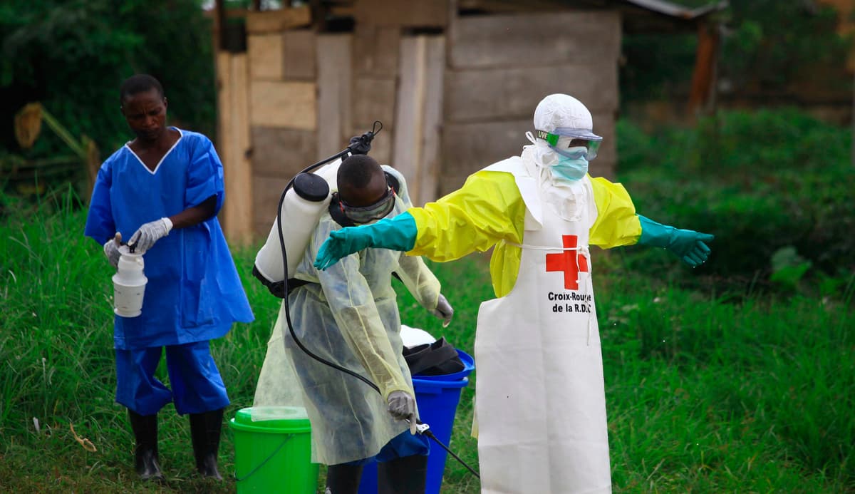 AP/Al-hadji Kudra Maliro, File A health worker sprays disinfectant on his colleague after working at an Ebola treatment center at Beni, eastern Congo, Sept 9, 2018.
