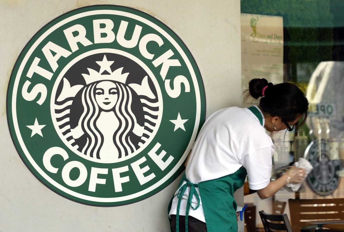 Photo by Chung Sung-Jun/Getty Images FILE: A Starbucks worker cleans the window next to a company logo at a coffee store on May 31, 2006, at Seoul, South Korea.