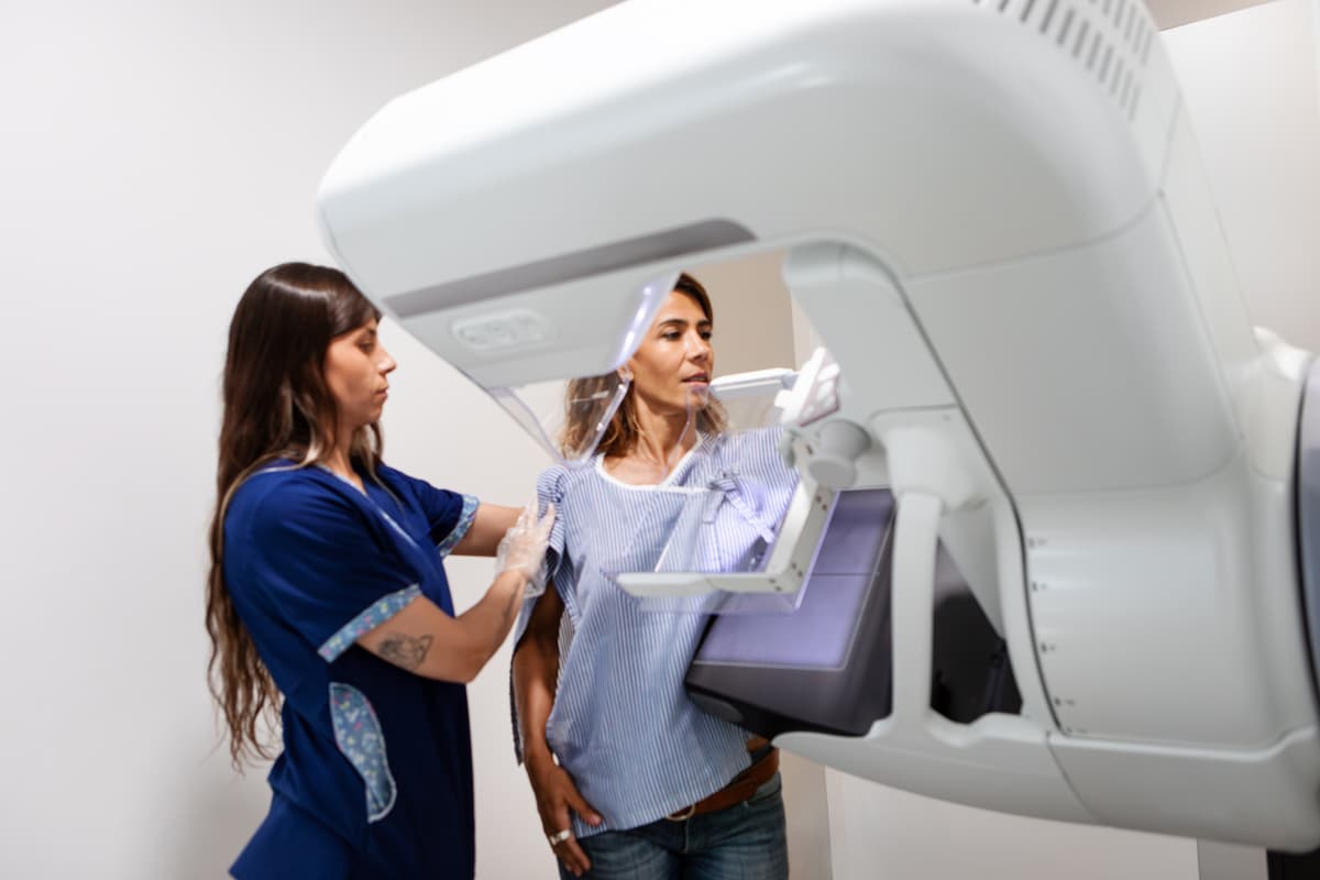 Getty Images
Young female radiology technician explaining and performing a breast exam on a middle-aged female patient using a state-of-the-art mammography machine.