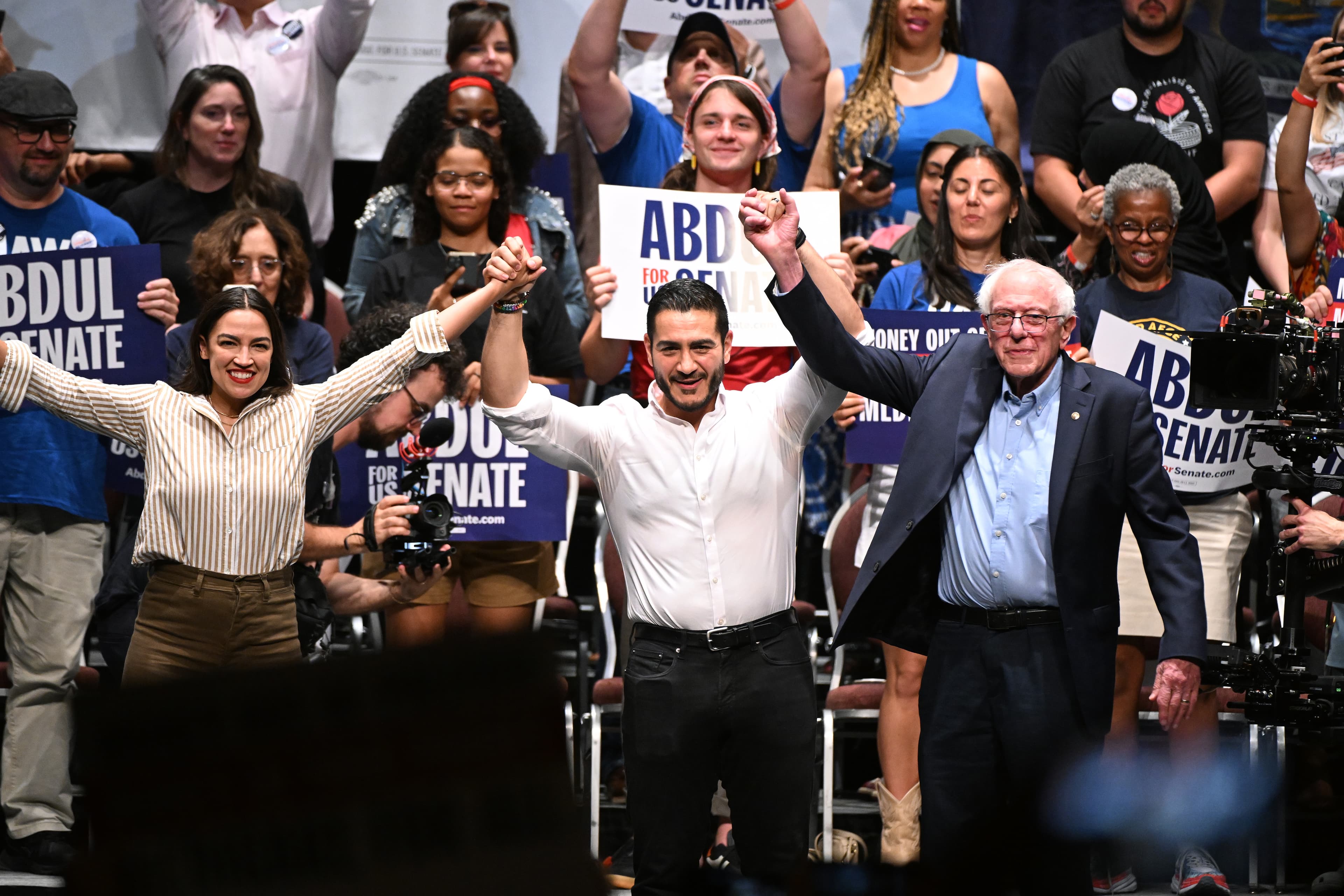 Congresswoman Alexandria Ocasio-Cortez, Michigan Democratic U.S. Senate primary candidate Abdul El-Sayed, and Senator Bernie Sanders join hands together following a campaign rally, July 18, 2026, at Detroit. Congresswoman Alexandria Ocasio-Cortez, Michigan Democratic U.S. Senate primary candidate Abdul El-Sayed, and Senator Bernie Sanders join hands together following a campaign rally, July 18, 2026, at Detroit.