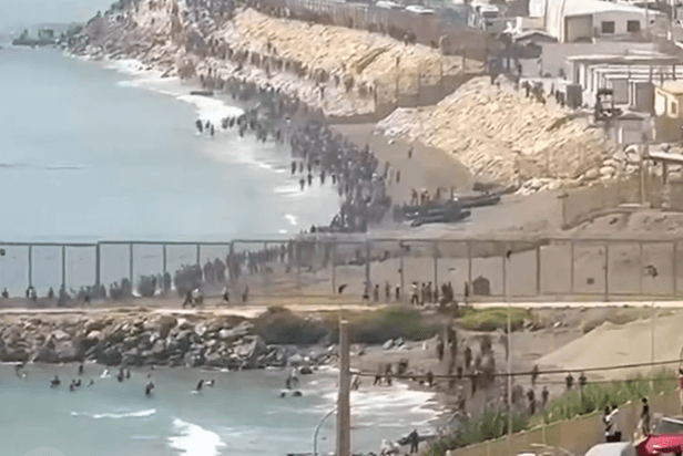 Via X Unauthorized migrants pour onto the beaches of Ceuta, a Spanish enclave bordering Morocco, on July 30, 2026.