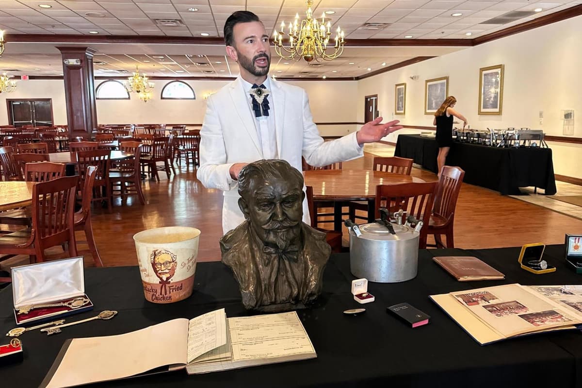 AP/Dylan Lovan Auctioneer Jonathan Klunk surrounded by items owned by Colonel Sanders on July 22, 2026, in Shelbyville, Kentucky.