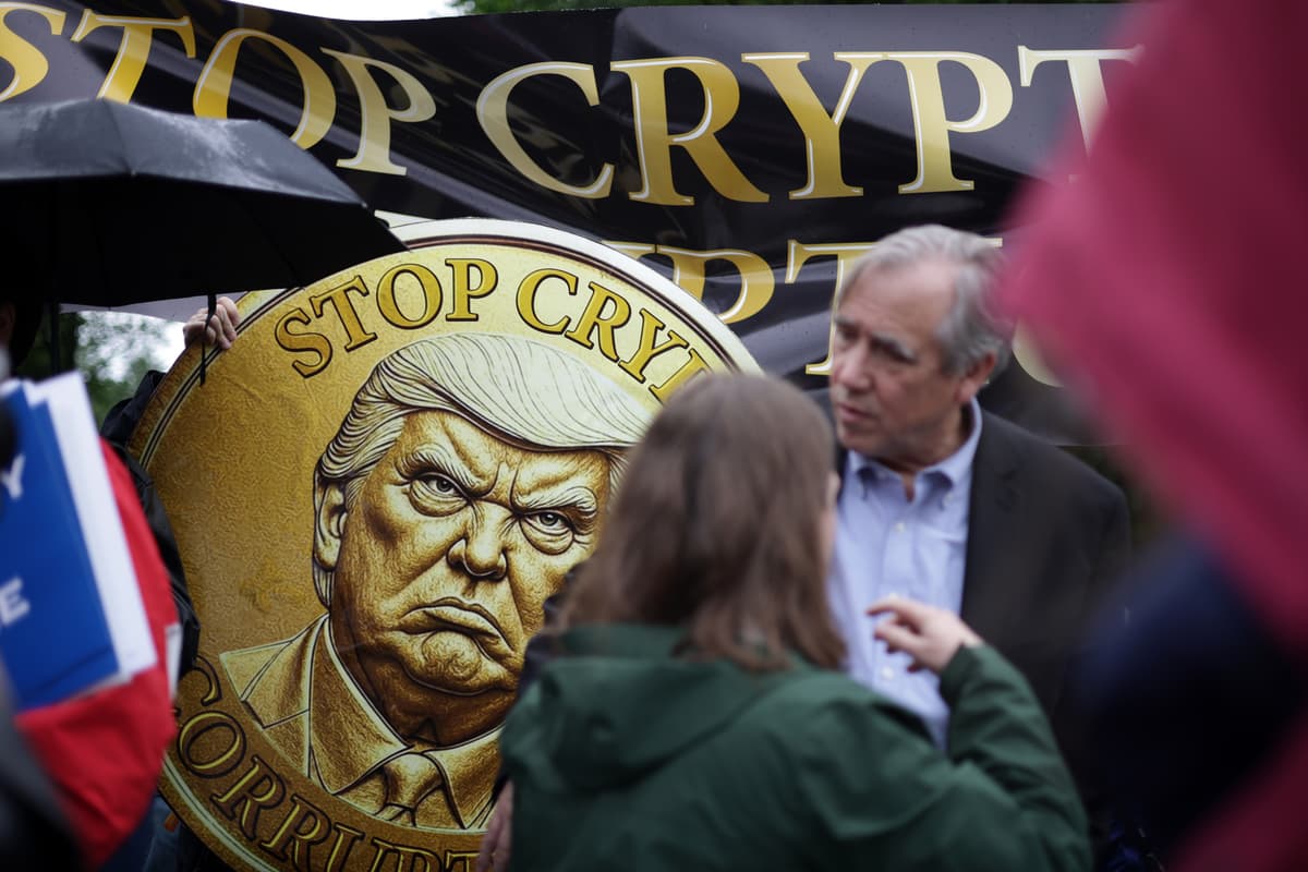 Alex Wong/Getty Images Demonstrators hold up a mock $TRUMP meme coin during a protest outside Trump National Golf Club at Sterling, Virginia, on May 22, 2025.