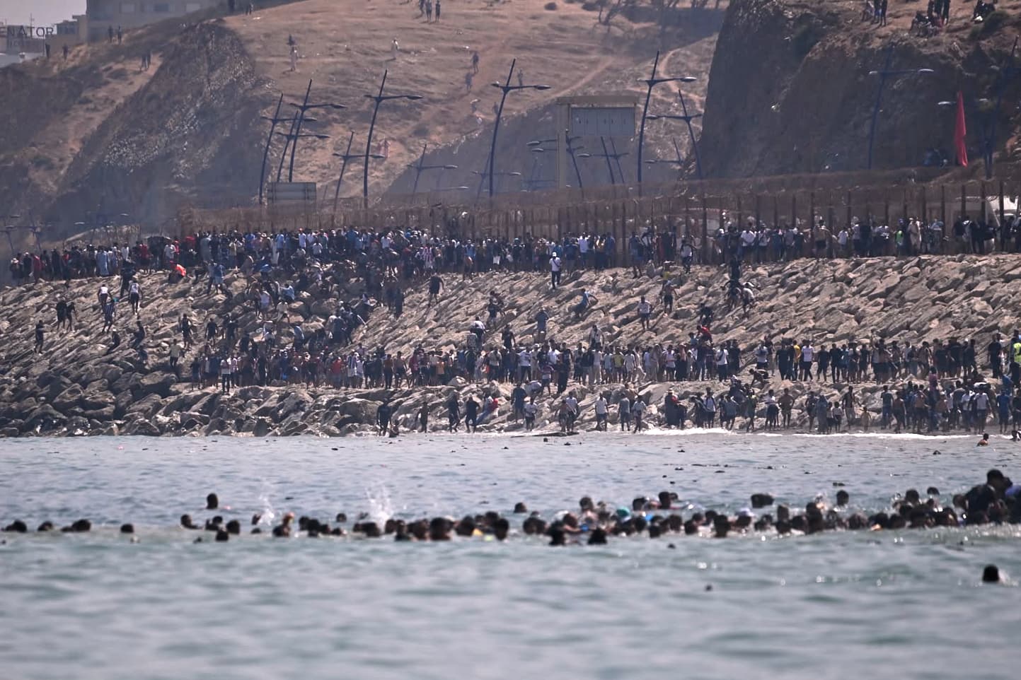 AP/Antonio Sempere Migrants cross into the Spanish enclave of Ceuta from Morocco, July 30, 2026.