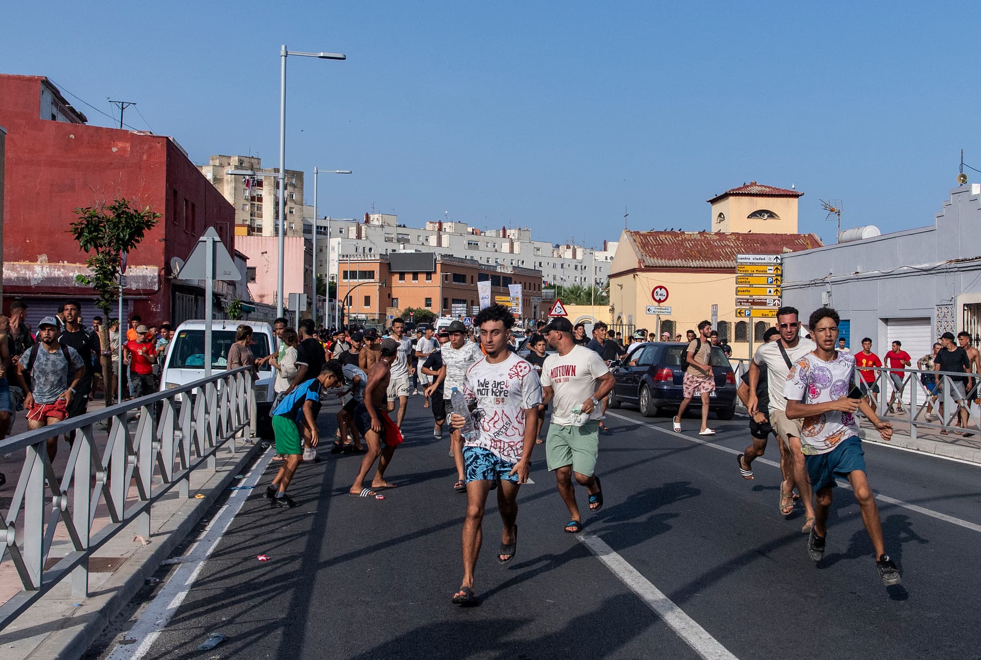 AP/Antonio Sempere Migrants run from police after crossing from Morocco into the Spanish enclave of Ceuta, July 31, 2026.