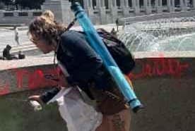 United States Attorney’s Office via X In a witness photograph released by federal prosecutors, a suspect is seen spray-painting the World War II Memorial at Washington D.C., on August 13, 2026.