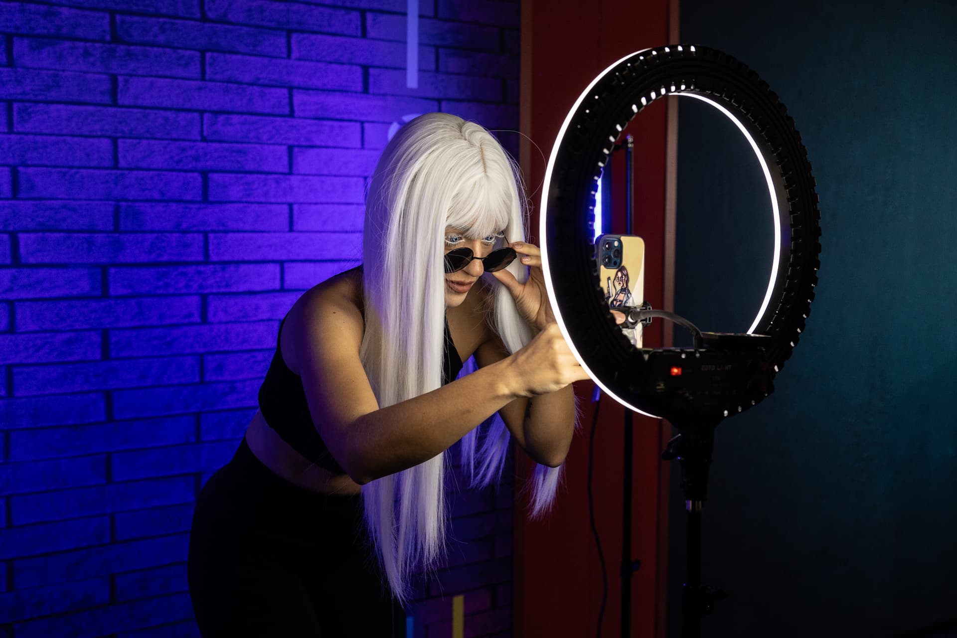 Emanuele Cremaschi/Getty Images A woman uses a ring light and her mobile phone to take a selfie.