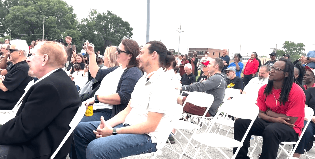 via Nebraska Examiner screen shot Member's of North Omaha's black community and activists listen to Omaha's first black mayor sing about a new government-backed grocery store.