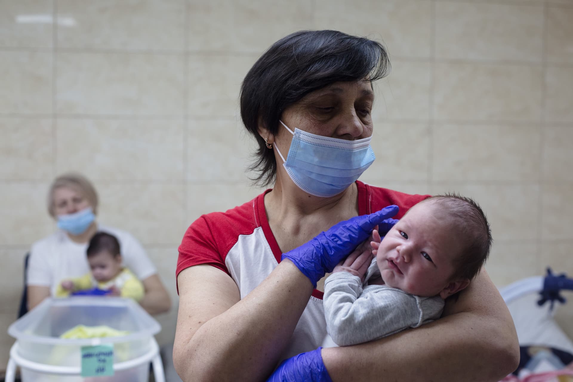 Anastasia Vlasova/Getty Images A nurse attends to a surrogate-born baby in a basement bomb shelter at Kyiv, Ukraine, on March 20, 2022.
