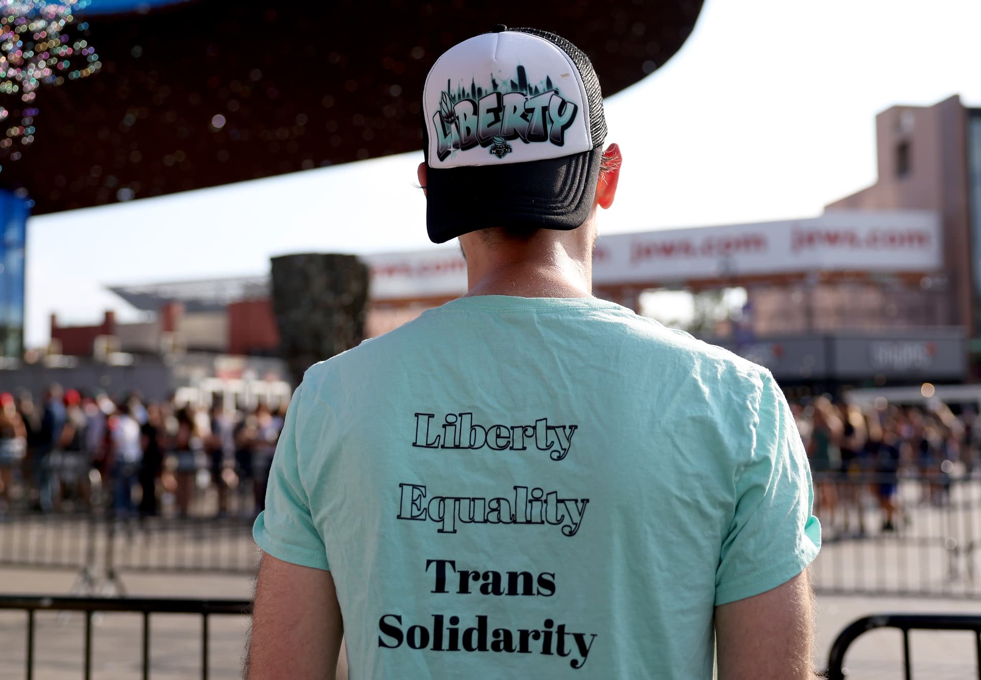 Getty Images Trans athlete supporters hold signs and flags outside the main entrance before the game between the New York Liberty and the Indiana Fever at Barclays Center on August 22, 2026 in Brooklyn.