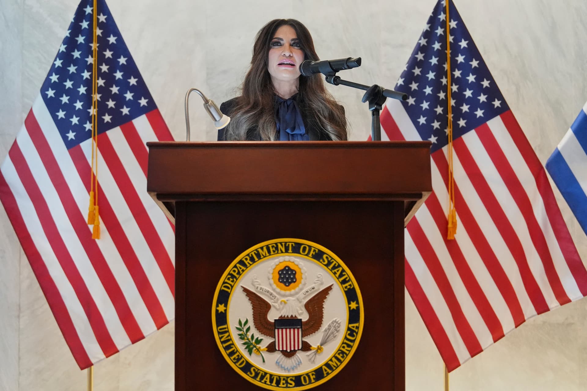 Photo by Mark Schiefelbein / POOL / AFP via Getty Images. U.S. Ambassador to Greece Kimberly Guilfoyle speaks during a dedication ceremony at the chancery of the US Embassy in Athens, on October 7, 2026.