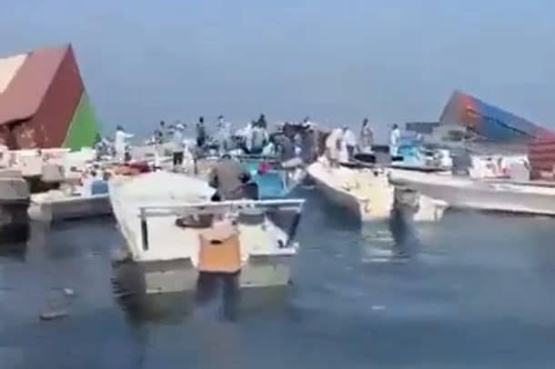 Via X In this screenshot from an eyewitness video, Omani residents are seen salvaging debris from the sinking of the container ship GFS Pride after its sinking on October 12, 2026.